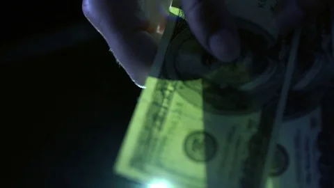 Considers money isolated on black background, against the light 4k Stock Footage 81733656