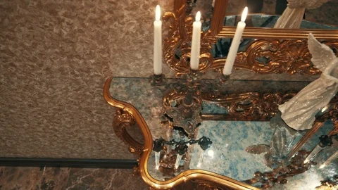 Console table with candles and mirror, half round table, dark marble with gold Stock Footage 99560920