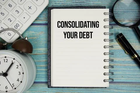 Consolidating Your Debt text on notepad with alarm clock, magnifying glass .. Stock Photos