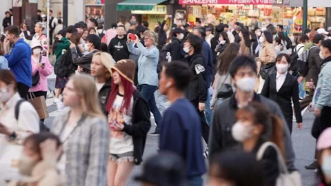 Constant flow of people crossing the expansive Shibuya Crossing Stock Footage 308877157