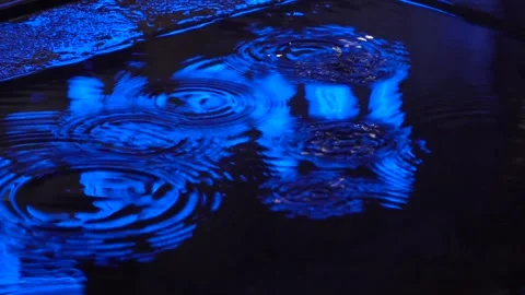 Constant ripples in a puddle reflecting neon lights 2 Stock Footage 295103805