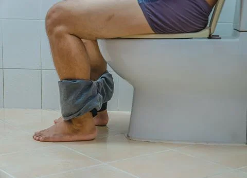 Constipated man sitting in the bathroom for a long time Stock Photos