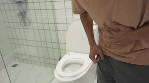 Constipation and diarrhea in bathroom. Hurt man touch belly  stomach ache p.. Stock Footage 336933829