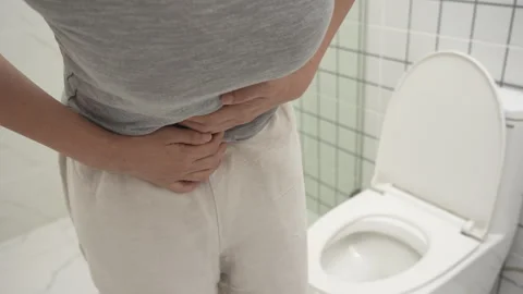 Constipation and diarrhea in bathroom. Hurt woman touch belly  stomach ache.. Stock Footage 337627203