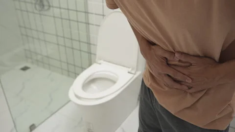 Constipation and diarrhea in bathroom. Hurt man touch belly  stomach ache p.. Stock Footage 337890348