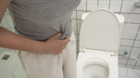Constipation and diarrhea in bathroom. Hurt woman touch belly  stomach ache.. Stock Footage 338311043