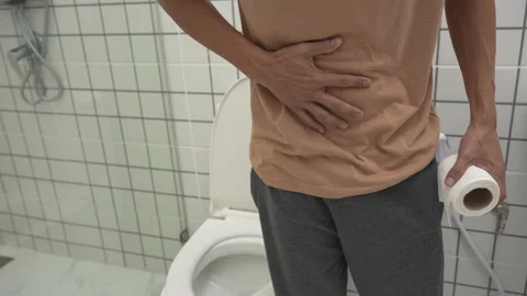 Constipation and diarrhea in bathroom. Hurt man touch belly  stomach ache p.. Stock Footage 338366801