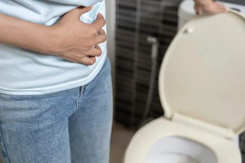 Constipation and diarrhea in bathroom. Hurt woman touch belly  stomach ache.. Stock Photos