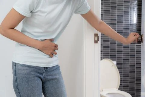 Constipation and diarrhea in bathroom. Hurt woman touch belly  stomach ache.. Stock Photos