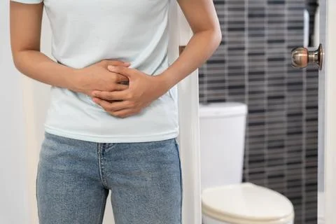 Constipation and diarrhea in bathroom. Hurt woman touch belly  stomach ache.. Stock Photos
