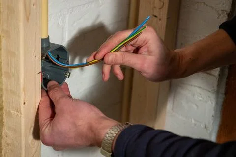 Constructing and installing electrical wiring  in a home using cavity wall .. Stock Photos