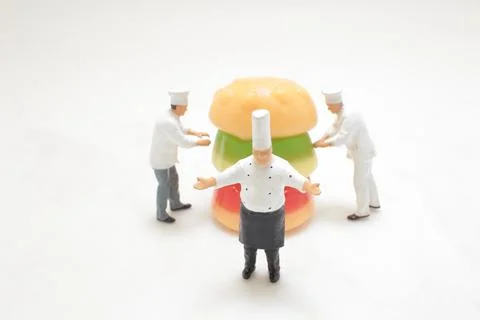 Constructing a Delicious Burger with mini chef Stock Photos