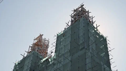 Constructing a tall building structure surrounded by scaffolding and cranes. The Video stock 345884814