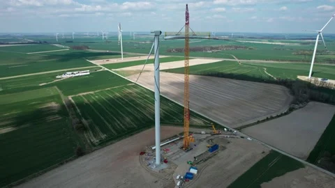 Constructing a wind farm, a crane lifts a windmill blade. Video stock 201150379