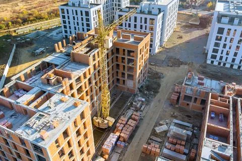 Construction activity in new building complex with cranes, brick stacks in .. 库存照片