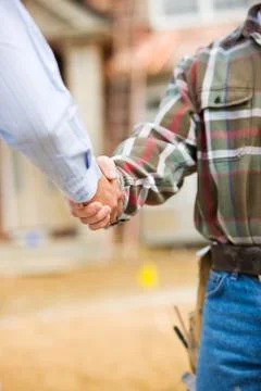 Construction: agent and contractor shake hands Stock Photos