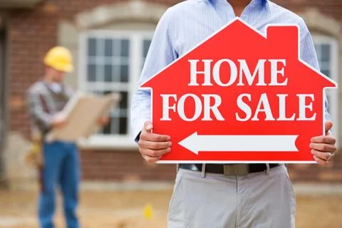 Construction: agent at open house holds sign Stock Photos
