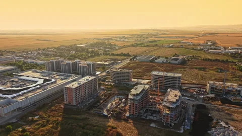 Construction area under sunset sky with buildings and farmland in the background Stock Footage 341392859