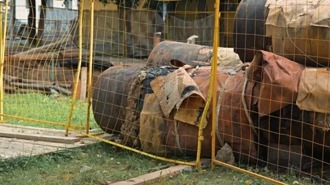 A construction area where barrels are placed on the ground behind a protective Vídeo Stock 344676059