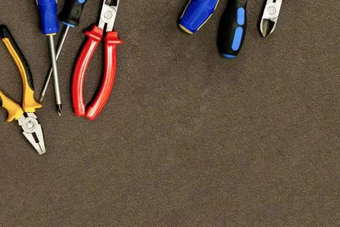 Construction background set of tools blue screwdriver cutting pliers on a dar Stock Photos