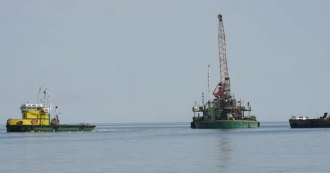 Construction Barge And Cargo Barge At The Sea Yellow-Green Boat Swims Away Stock Footage 54220364
