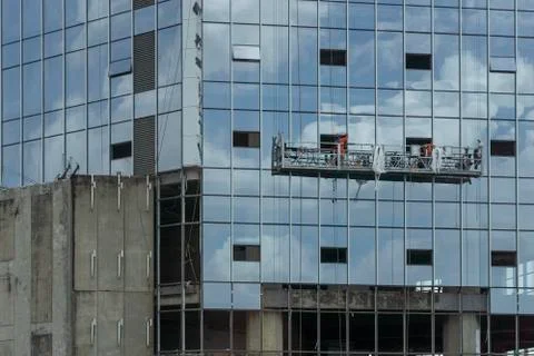 Construction baskets blue next to the building with workers Stock Photos