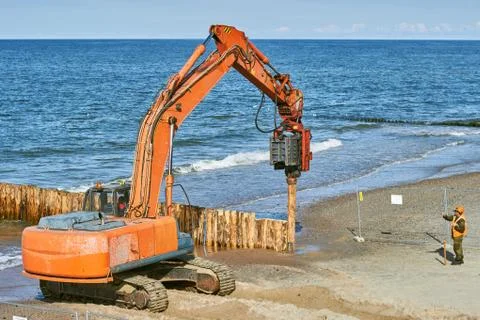 Construction of breakwaters from tree trunks on the sea coast Stock Photos