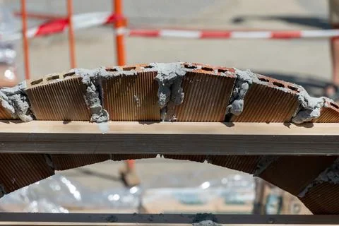 Construction of a brick arch with the wooden structure and the plaster to join Stock Photos
