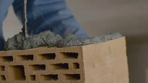 Construction of brick wall. Trowel spreading cement on bricks. Worker spreads Stock Photos