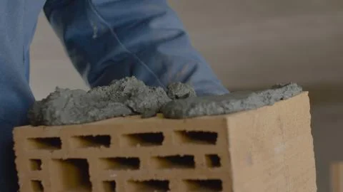 Construction of brick wall. Trowel spreading cement on bricks. Worker spreads Stock Photos