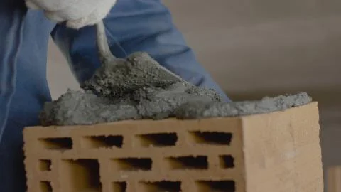 Construction of brick wall. Trowel spreading cement on bricks. Worker spreads Stock Photos