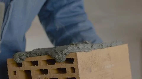 Construction of brick wall. Trowel spreading cement on bricks. Worker spreads Stock Photos