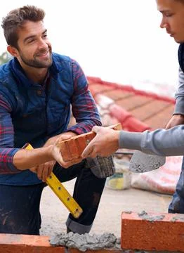 Construction, bricklayer and men build with brick, handyman or contractor with Stock Photos