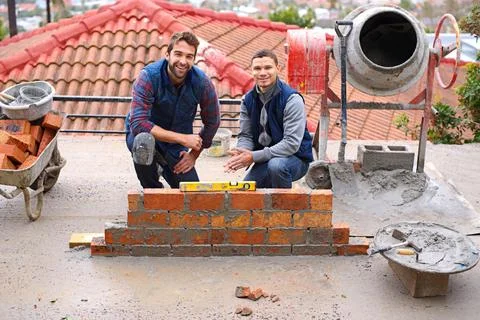 Construction, bricklayer and men building a brick wall, handyman or contractor Stock Photos