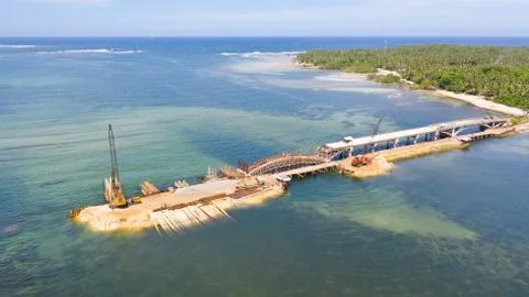 Construction of a bridge across the bay. Construction equipment on the bridge Stock Photos