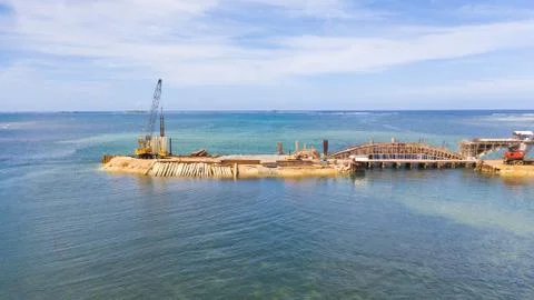 Construction of a bridge across the bay. Construction equipment on the bridge Stock Photos