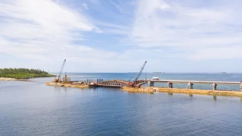 Construction of a bridge across the bay. Construction equipment on the bridge Stock Photos