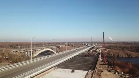 Construction of a bridge across the river. Automobile traffic on the bridge. Stock Footage 196387507