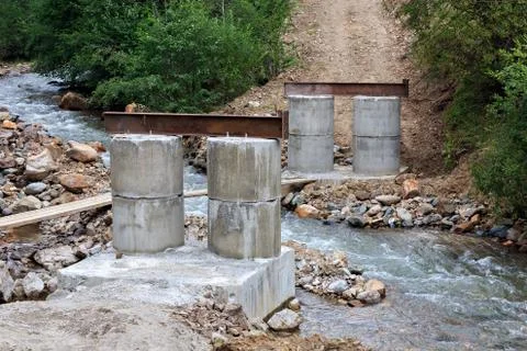 Construction of a bridge over a mountain river. Stock Photos
