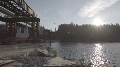 Construction of a bridge over the river, sunset, bright sun Stock Footage 275336373