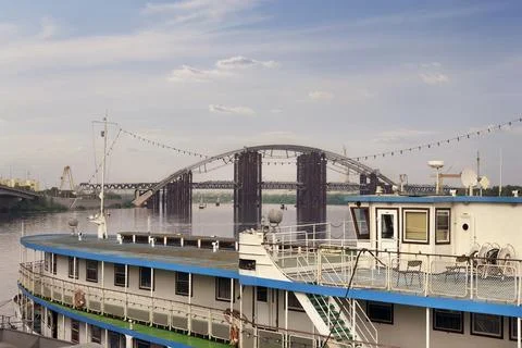 Construction of the bridge. A river craft moored near the shore, against the  Stock Photos