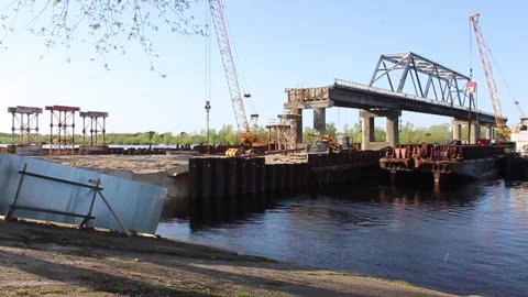Construction of the bridge. Tractor brings building materials	 Stock Footage 332514357