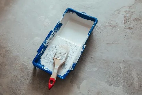 Construction brush in a container of white paint Stock Photos