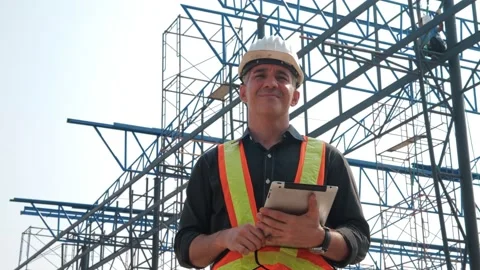 Construction builder in hardhat with the tablet on a construction site Video stock 157626321