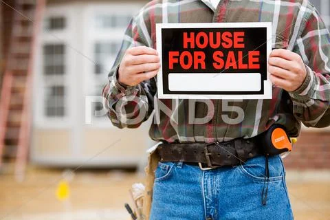 Construction: builder holds up sale sign Stock Photos