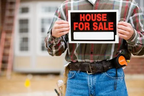 Construction: builder holds up sale sign Stock Photos