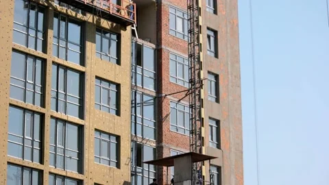 Construction building and moving elevators with workers on board. Vídeos de archivo 194935775