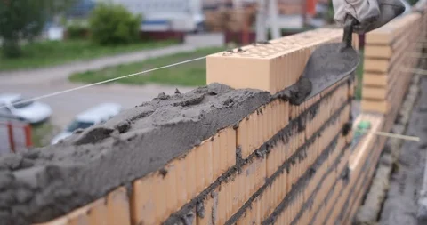 Construction of building, close-up worker quickly, efficiently erects brickwork Stock Footage 116792585