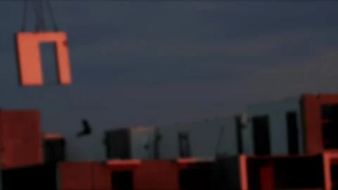 Construction of building with crane lifting pre-fabricated wall panel containing Stock Footage 326748502