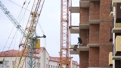 Construction. Building. Cranes. Worker on balkony. Video stock 53825302